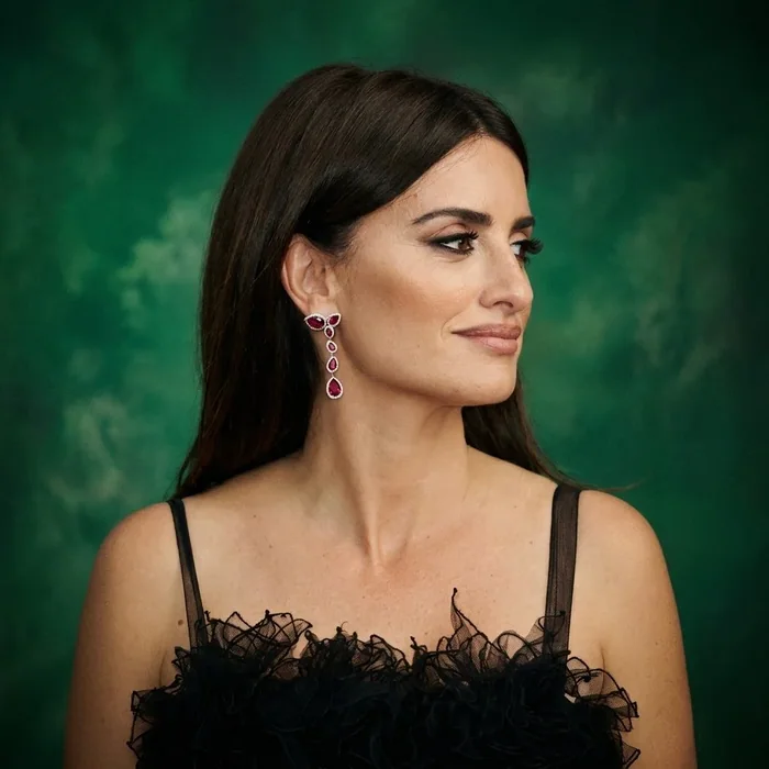 A woman wearing ruby and diamond drop earrings by Prins and Prins