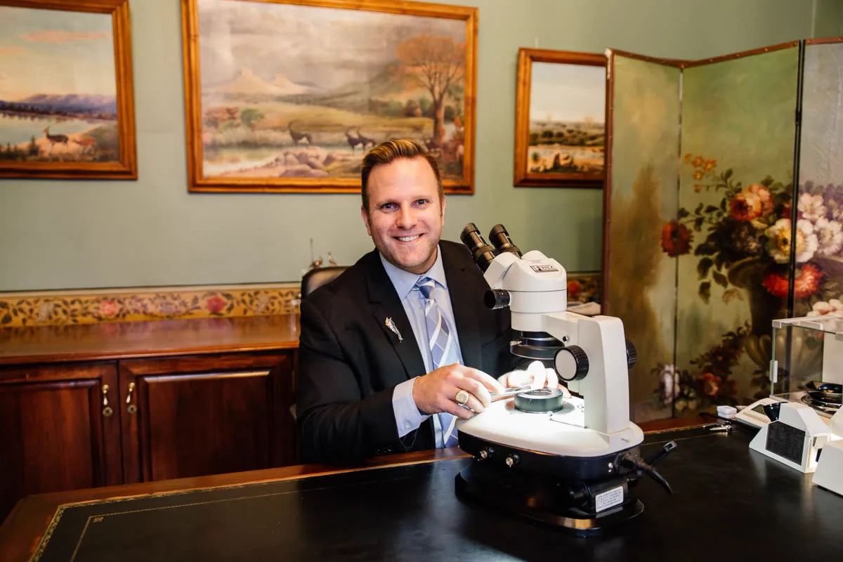 A Prins and Prins GIA-qualified gemmologist examining a gemstone under the microscope