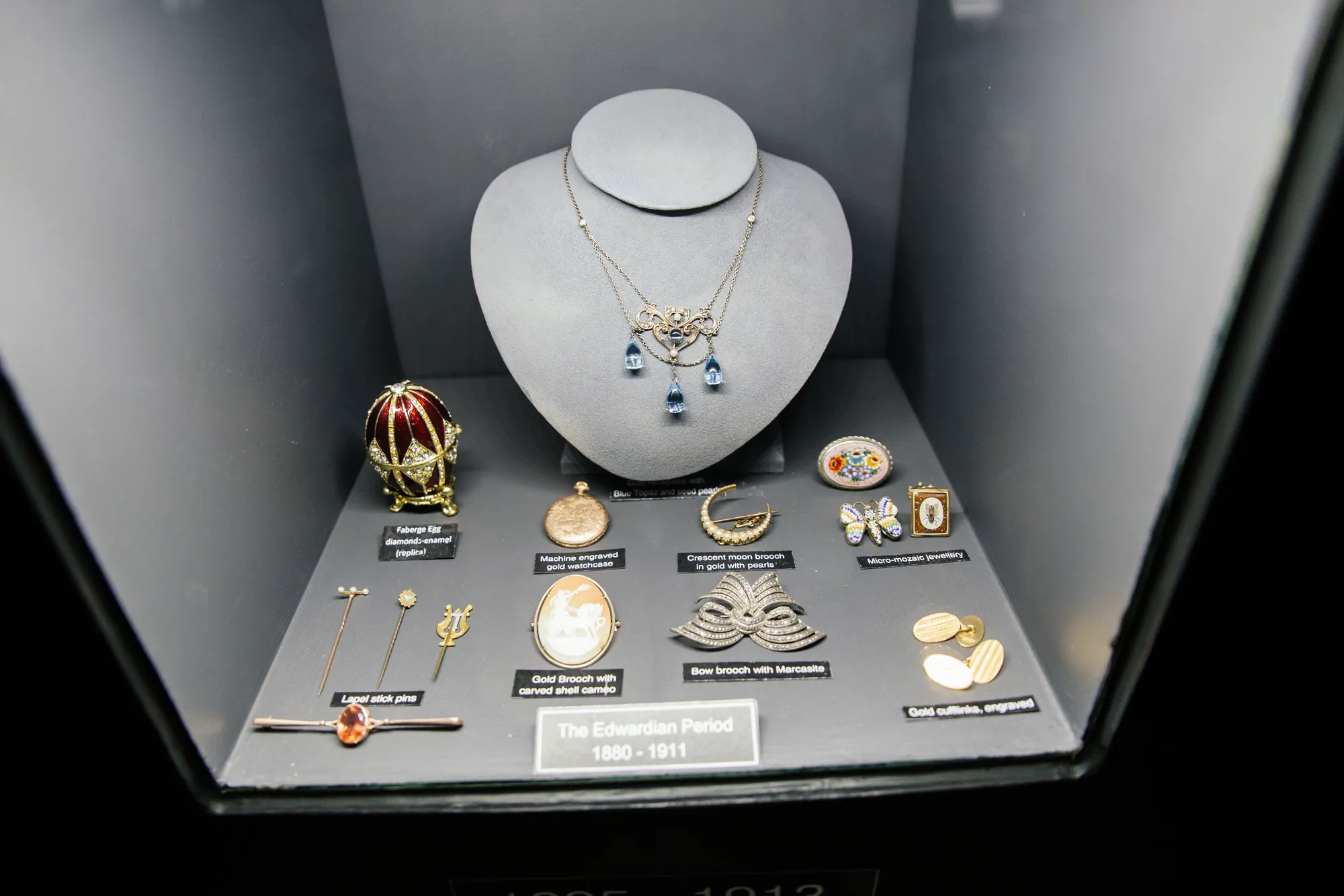 The Edwardian Period display case in the Prins and Prins Museum of Gems and Jewellery, with a gold blue-topaz necklace, a Fabergé egg and antique brooches
